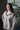 Woman wearing a gray hoodie with 'Body Haus' text, standing indoors with a plant in the background.